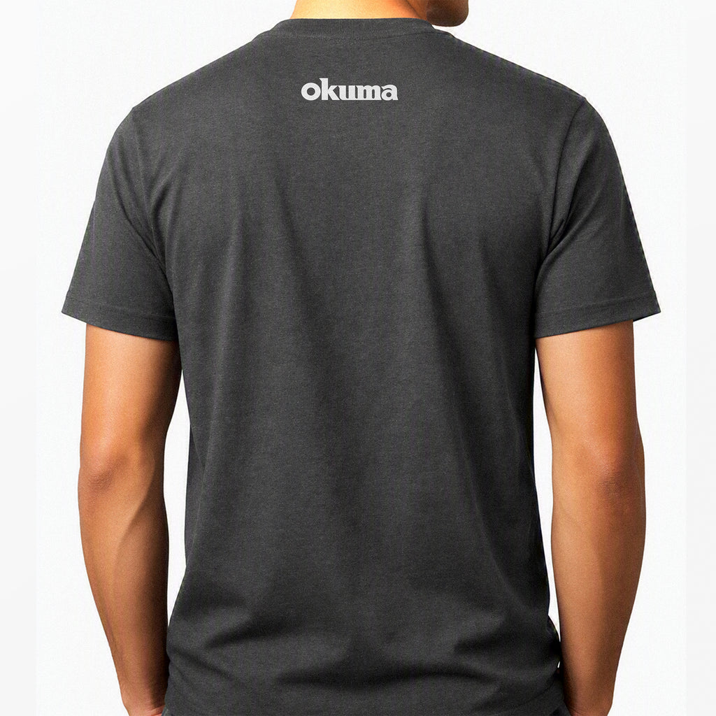 A man wearing a dark gray heather t-shirt, viewed from the back. The shirt features the brand name 'okuma' printed in white across the upper back.