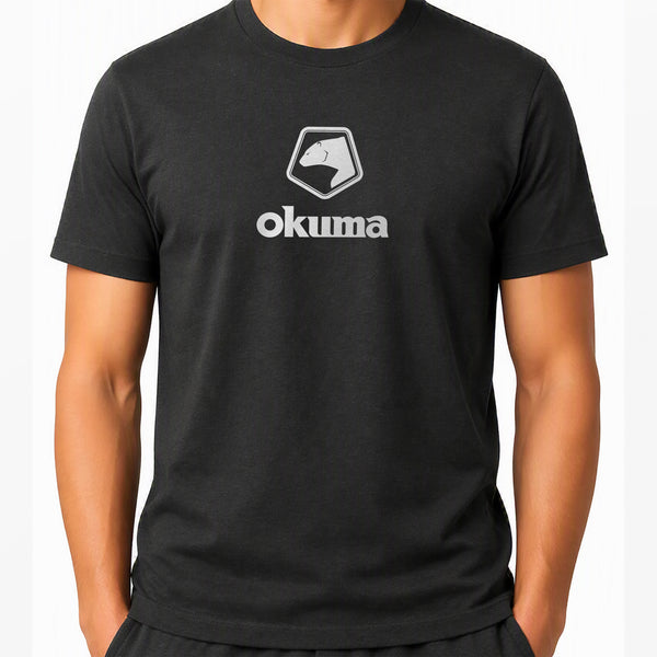 A man wearing a black short-sleeve crewneck t-shirt with a white printed Okuma logo on the chest, shown against a plain white background.