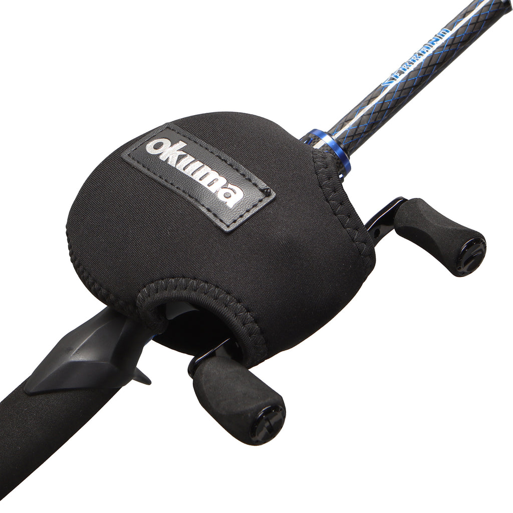 Close-up of a black Okuma fishing rod handle cover with a stitched neoprene sleeve and a visible Okuma logo patch, mounted on a fishing rod against a white background.
