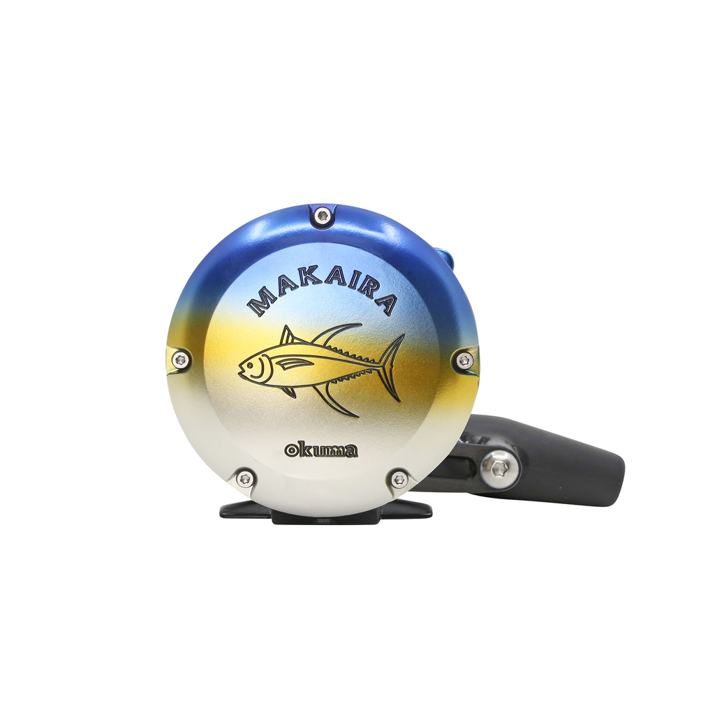 A circular fishing reel cover with a blue-to-white-to-yellow gradient design, featuring a tuna fish graphic and the text 'MAKAIRA' and 'Okuma'. A black handle is attached to the right side, set against a plain white background.
